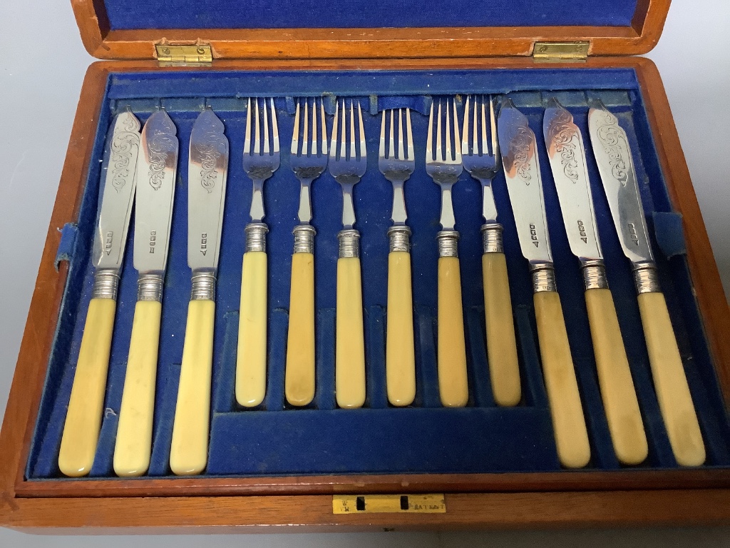 Twelve pairs of Walker & Hall silver-bladed bone-handled fish eaters, a set of six silver Apostle teaspoons and sugar tongs and a set of twelve silver coffee spoons